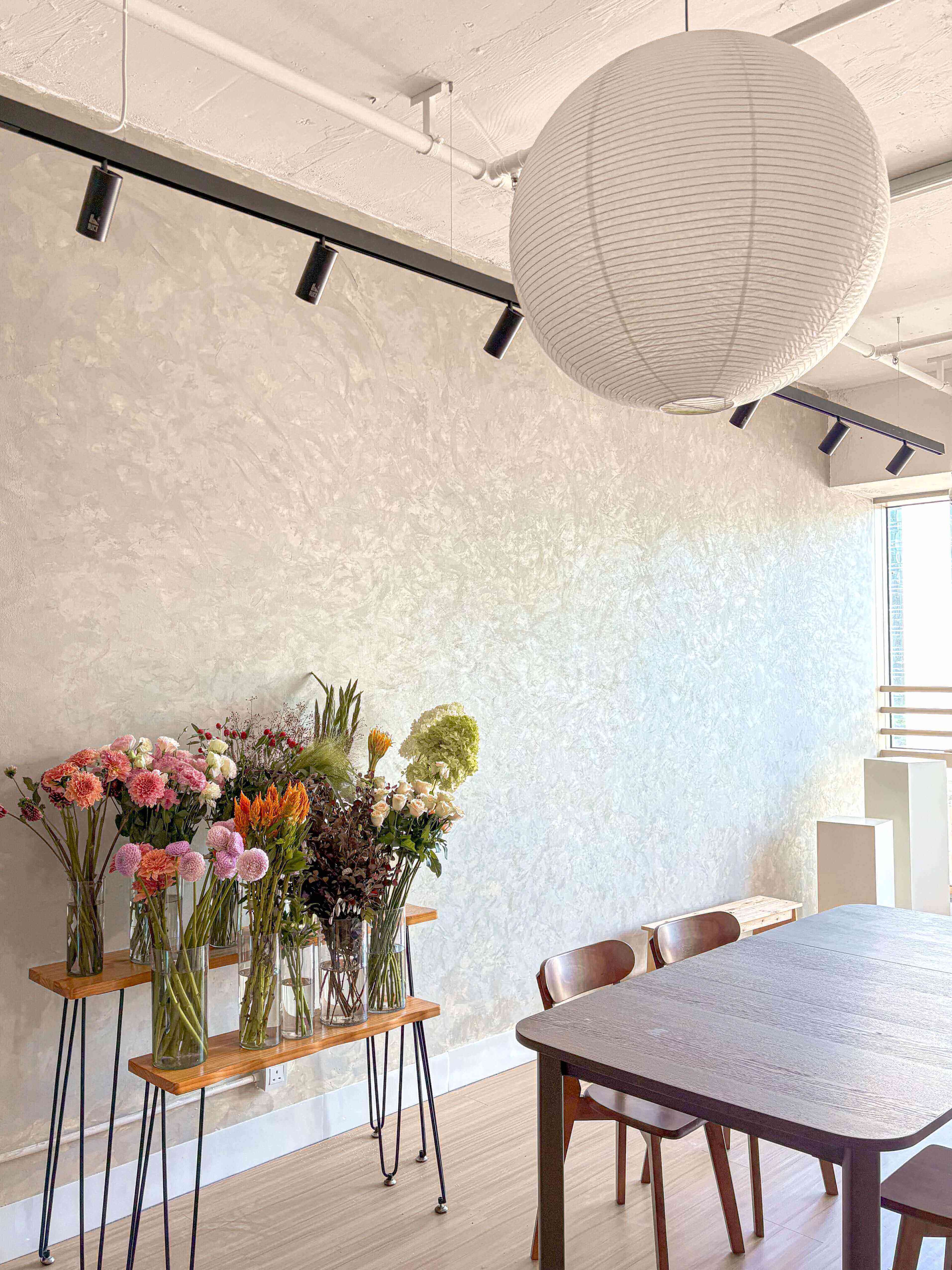 香港花藝課程課室，Let Hope Bloom Florist導師正在教授學生插花技巧，桌上擺滿鮮花花材。